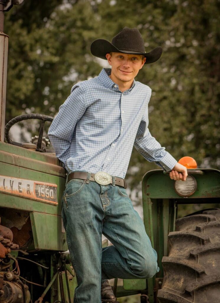 young man standing by tractor