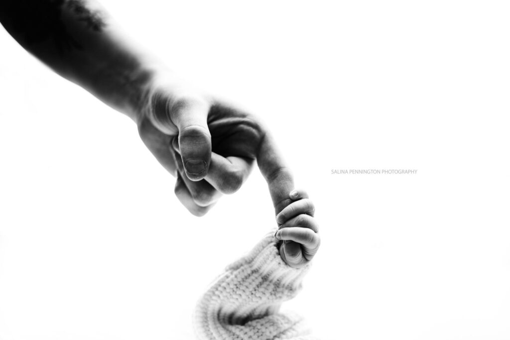 newborn holding parents fingers