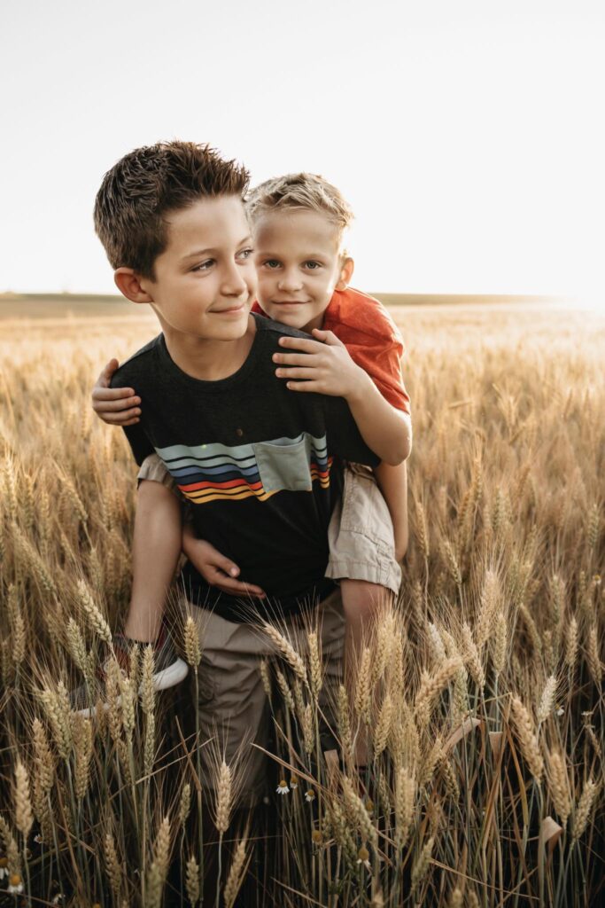 older and younger brother in wheat field