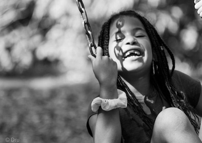 young girl laughing on swing