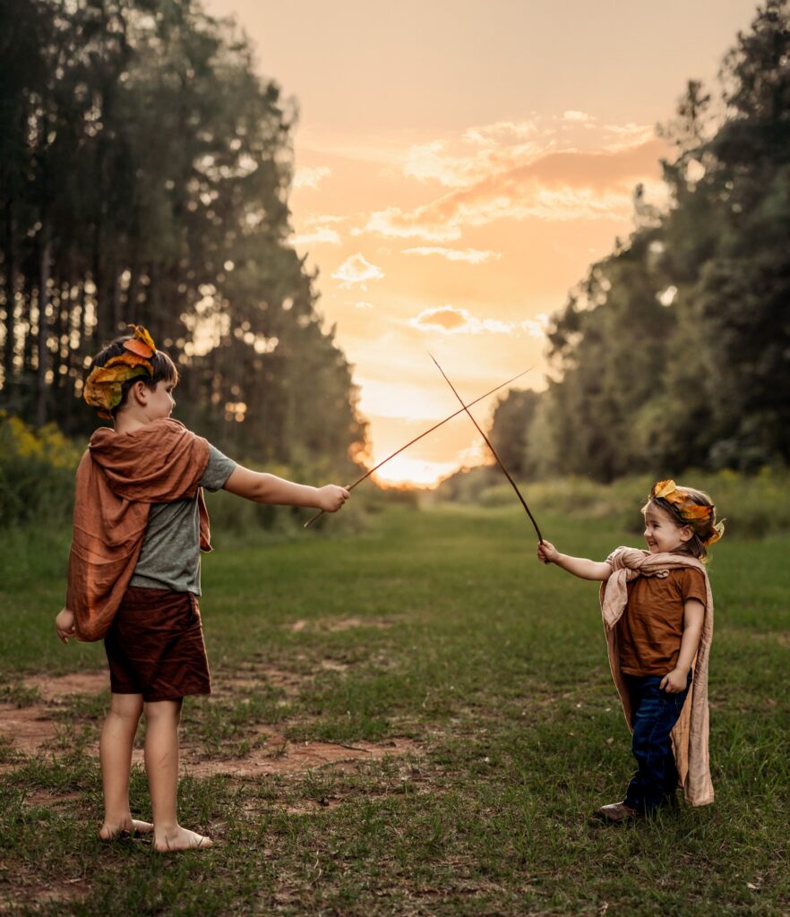 two siblings playing with sticks using imagination