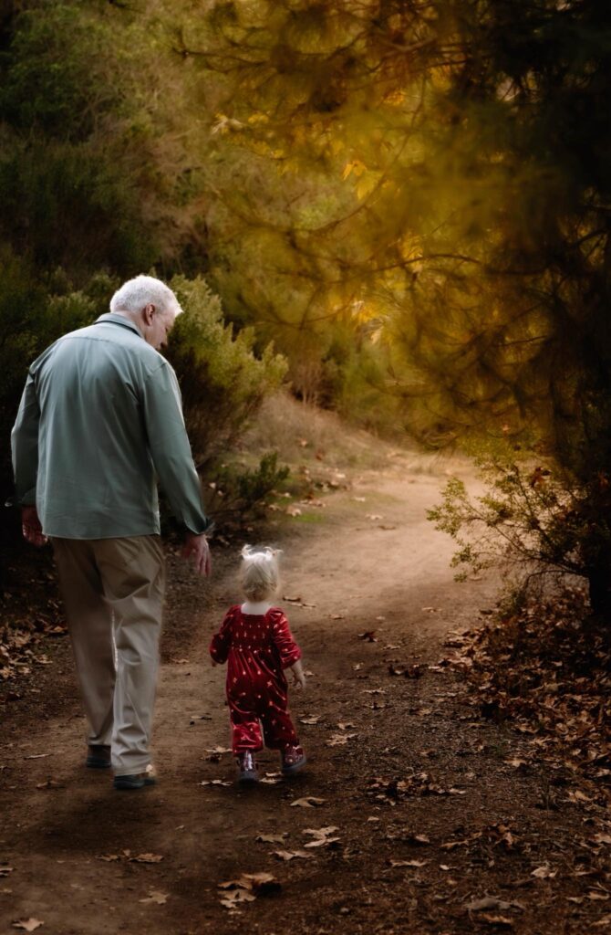 elderly man walking with grandchild on nature walk