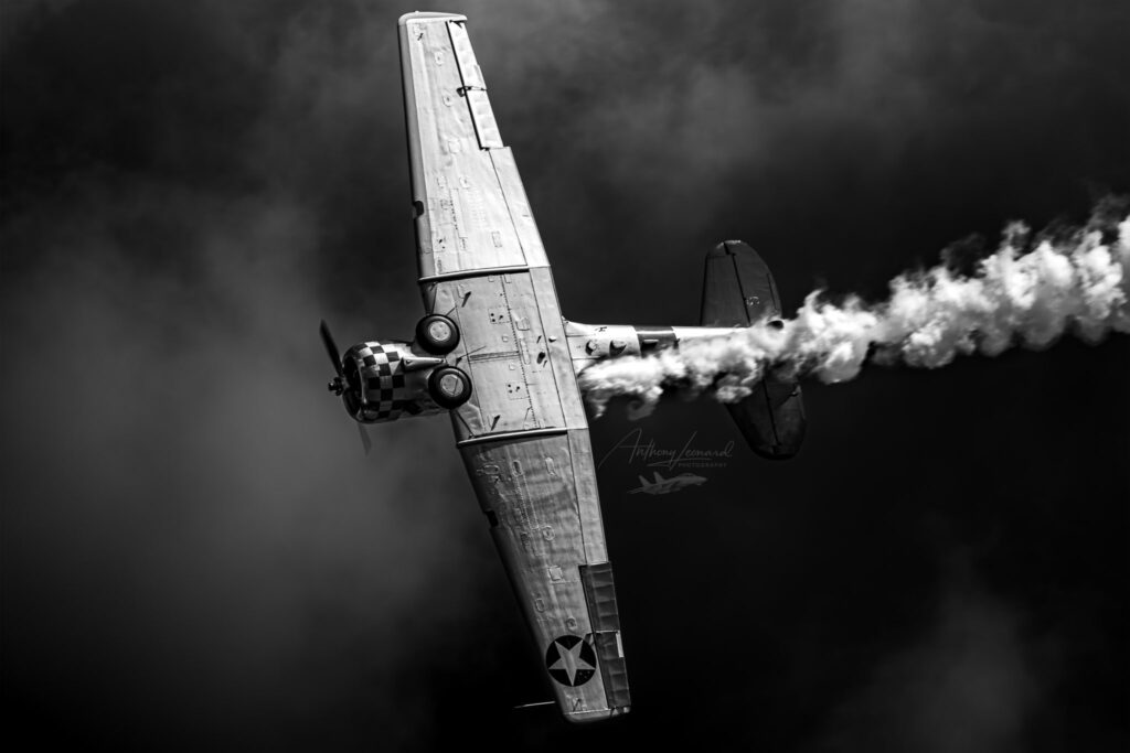 black and white photo of airplane in the sky