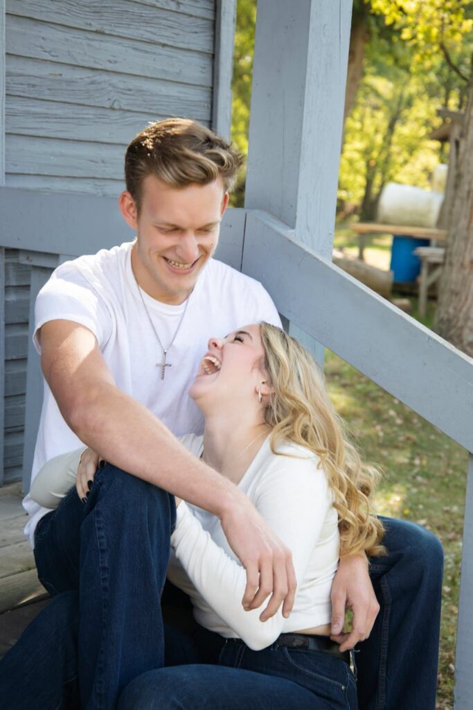 couple looking at each other and laughing while sitting on steps