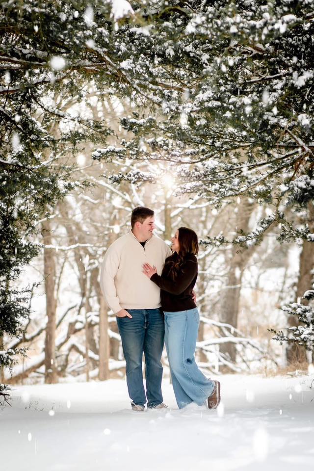 engagement couple looking at each other in snow