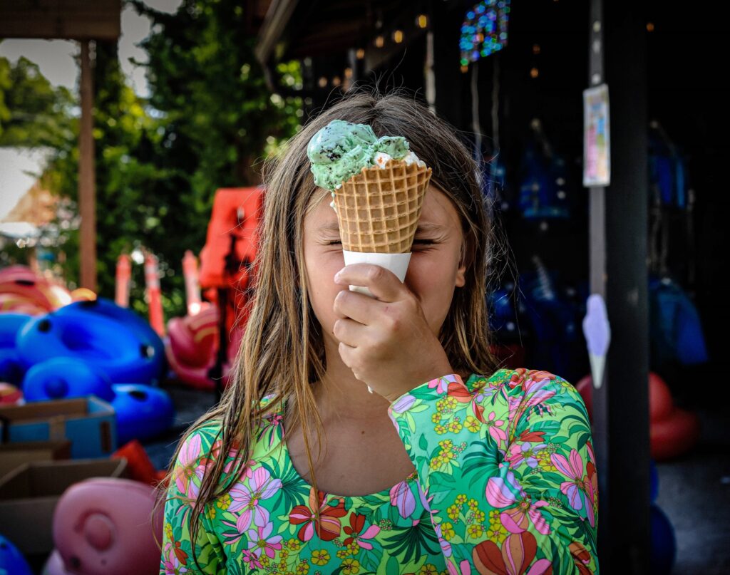 capture of girl holding a big ice cream sone in front of her face
