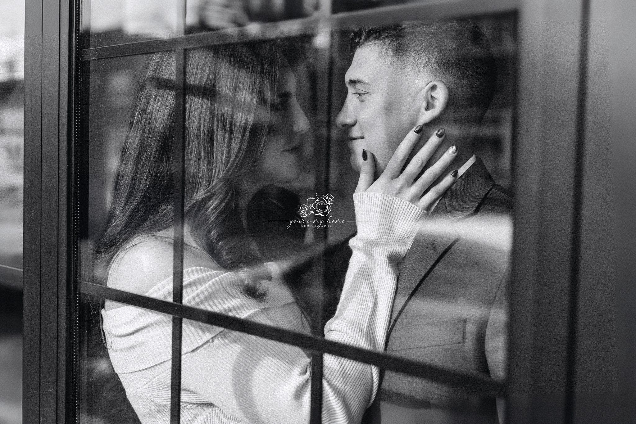 woman and man gazing into each others eyes right next to window