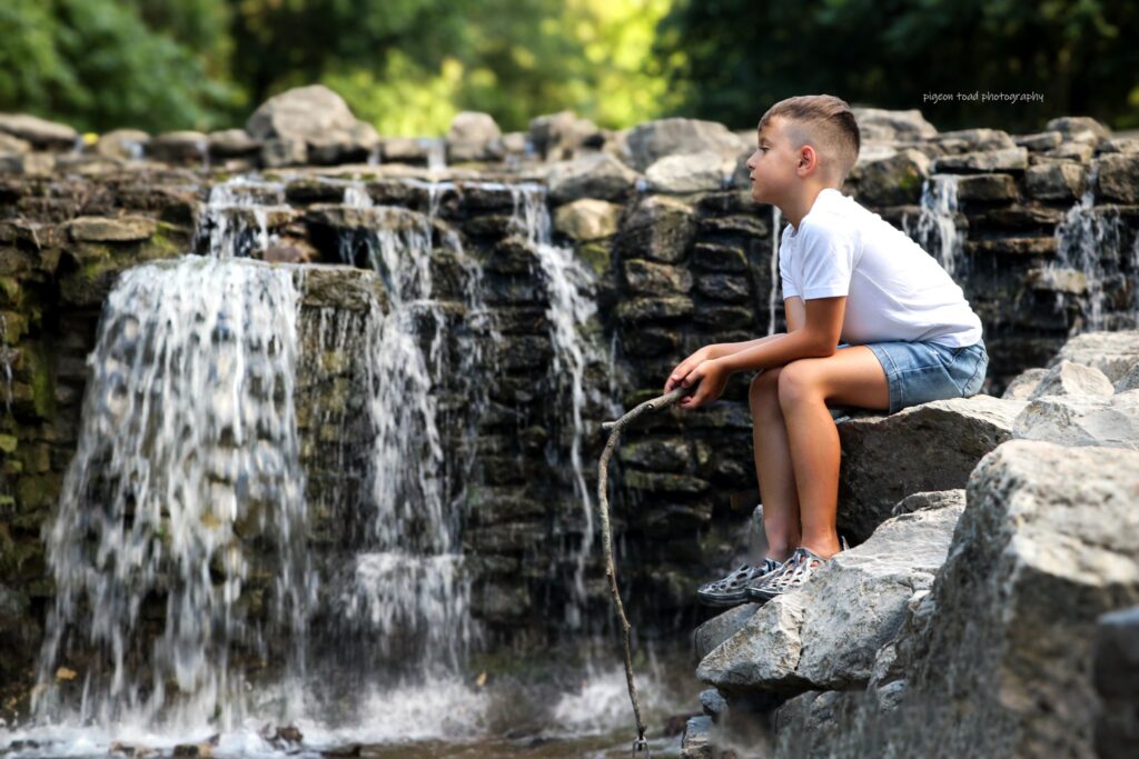 child sitting next to a small river