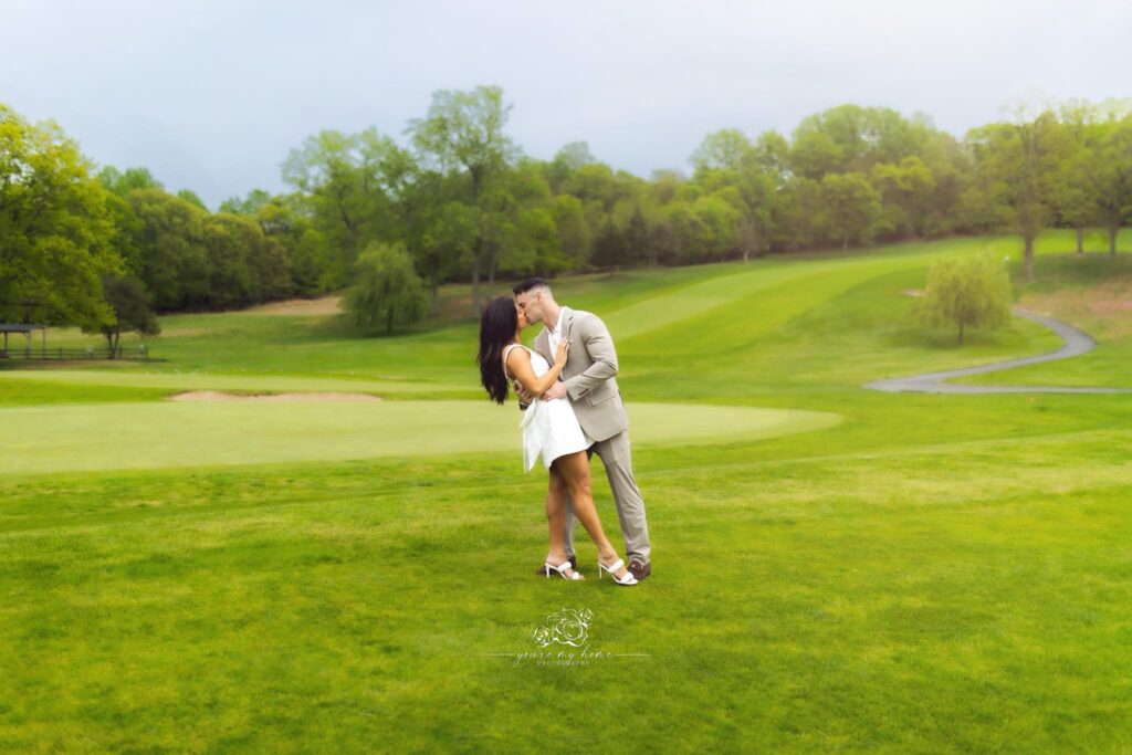 Couple kissing in the middle of a golf course