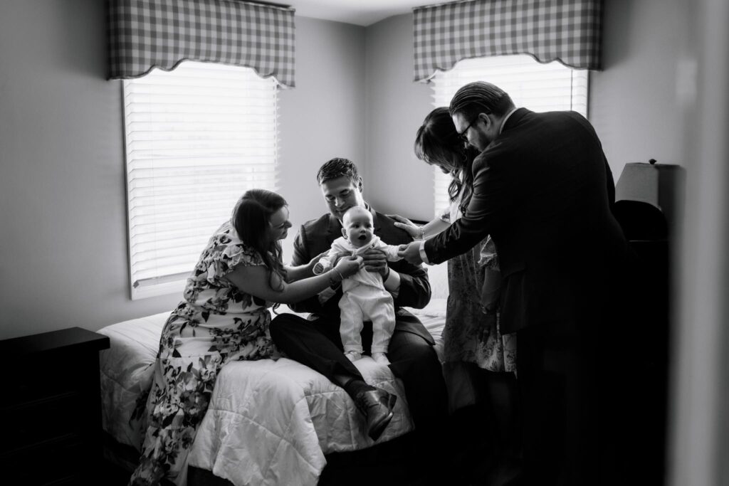 black and white portrait with family surrounding a baby