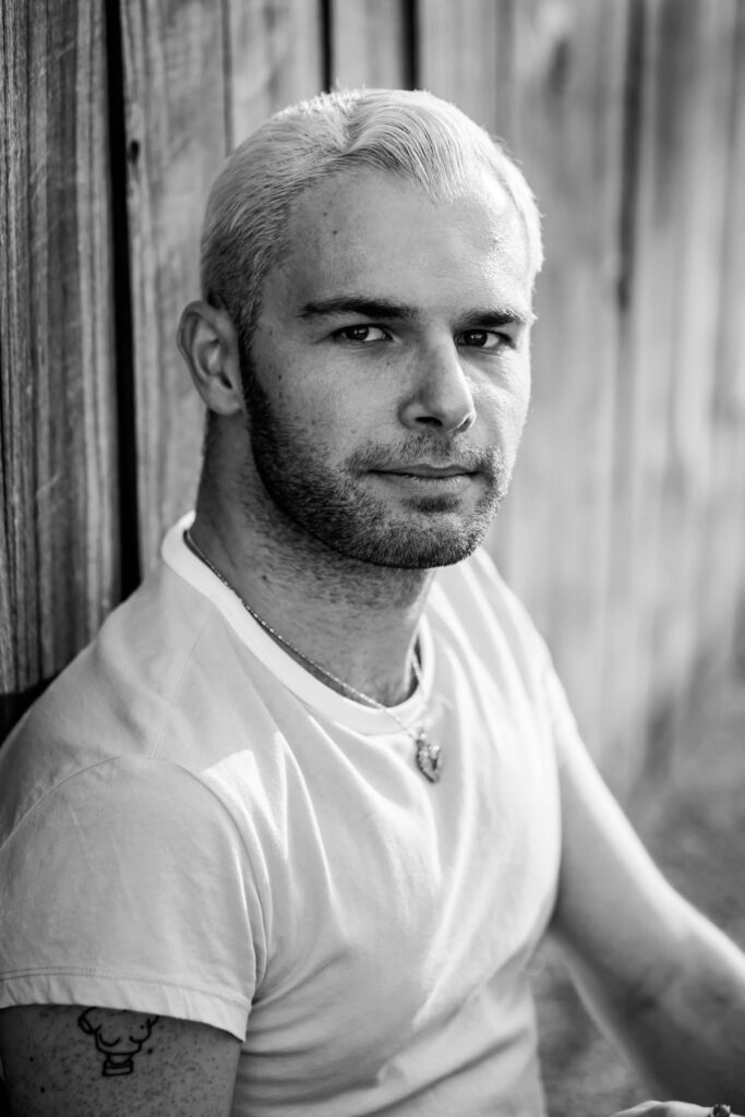 black and white portrait of young man in front of textured background