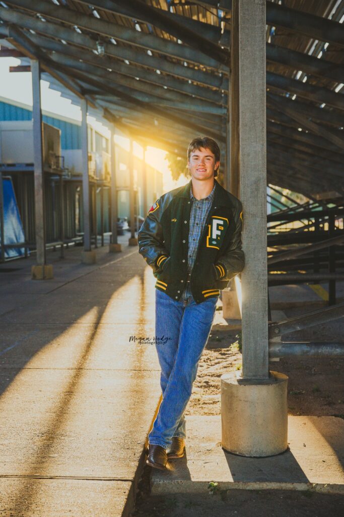 senior portrait under bleachers back light with sunflare