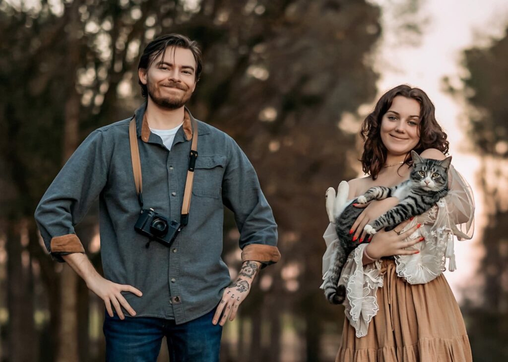 brother and sister portrait, one holding a camera and the other hold ding a cat , evening light