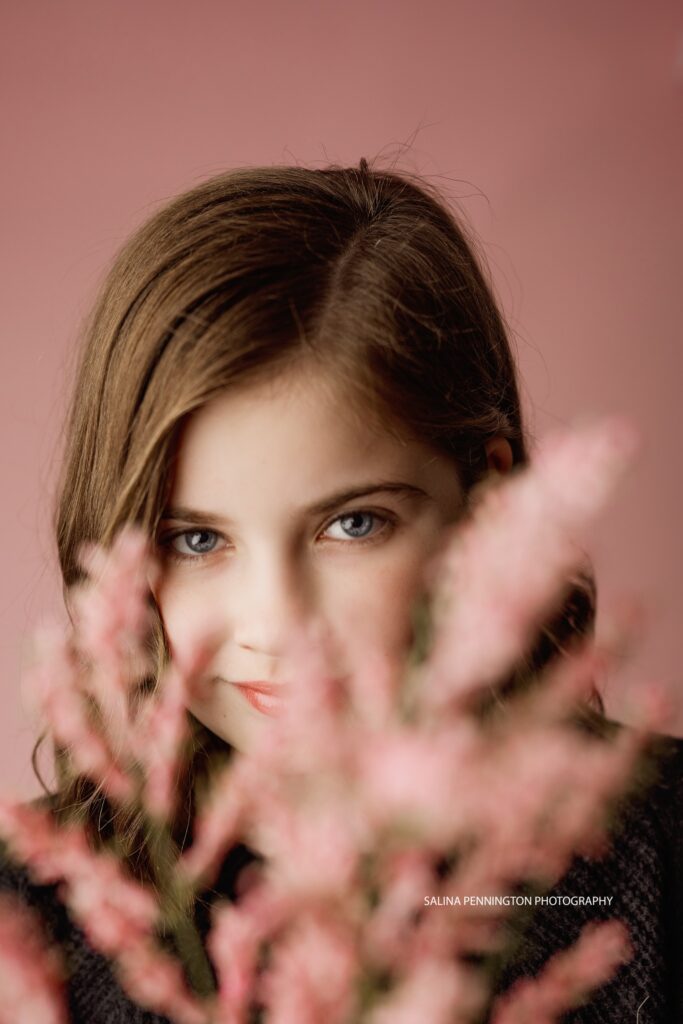 spring portrait girl holding pink flower with pink background